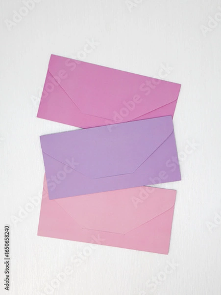 Obraz Three pink and lilac closed envelopes for money lie on white background, message concept