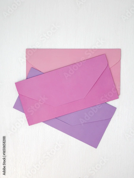 Obraz Three pink and lilac closed envelopes for money lie on white background, message concept