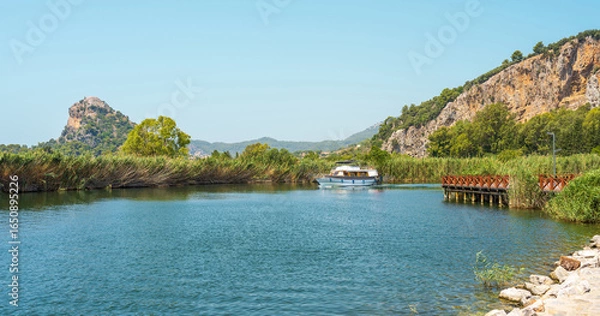 Fototapeta Scenic Dalyan river view with boat and rocky hills