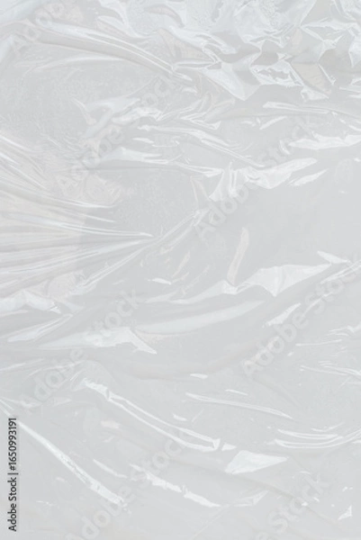 Fototapeta Crumpled plastic wrap with reflective surface. Great for design projects needing a textured, modern look with a sleek aesthetic.