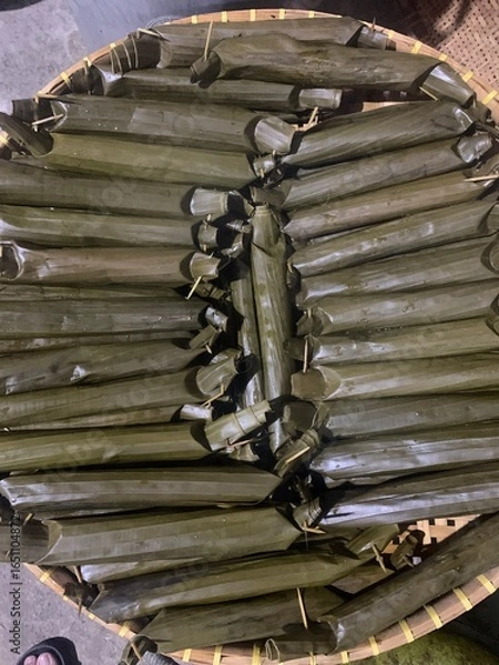 Fototapeta Lontong is a traditional Indonesian dish made from rice that is boiled and compressed in banana leaves, then cut into small cylindrical or round pieces. The texture is firm yet soft, and it has a mild