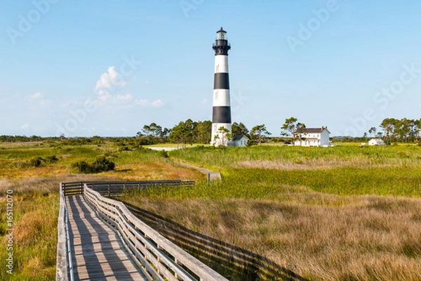 Obraz Wooden ramp over marshland, with a boardwalk trail to the Bodie Island lighthouse and surrounding buildings, on the Outer Banks of North Carolina near Nags Head.  