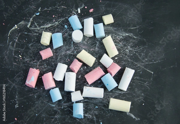 Fototapeta Broken colored chalk on black board background