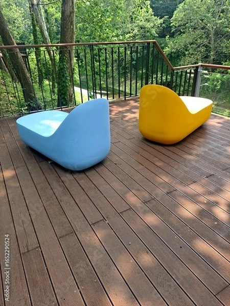 Fototapeta Colorful chairs by the stream in the sun shinning forest park in Seoul, South Korea