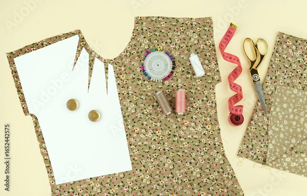 Fototapeta Modeling and cutting of clothes from soft fabric in the form of a panorama. Drawing of a blouse from paper, tailor's scissors, sewing accessories on a beige background.