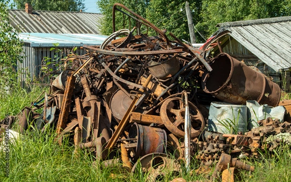 Fototapeta a pile of rusty iron on the grass