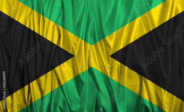 Fototapeta Vibrant Jamaican flag flowing in the breeze under bright sunlight