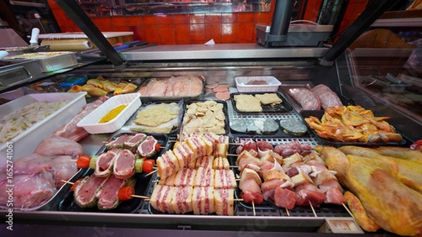 Fototapeta Traditional butcher shop meat display counter filled with fresh cuts for customers