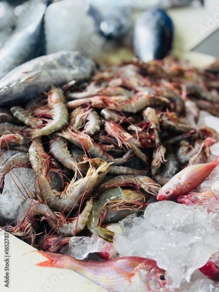 Fototapeta Fresh chemmeen (prawns) displayed in a local seafood shop, showcasing natural texture and market atmosphere, perfect for themes of seafood, cooking, fishing, and local trade.