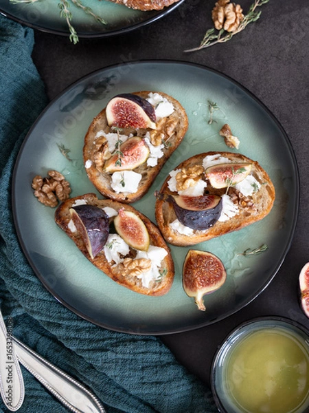 Obraz Close-Up Top View of Three Fig and Goat Cheese Toasts with Honey and Cutlery