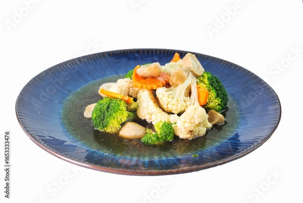 Fototapeta Stir-fried mixed vegetables with broccoli, cauliflower, carrots and straw mushrooms isolated on white background
