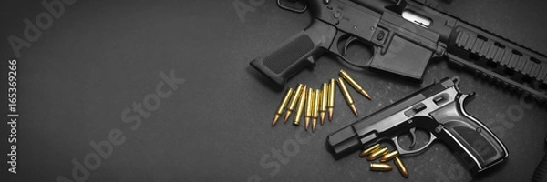 Obraz Pistolet z karabinem i amunicją na ciemnym tle z kopii przestrzenią