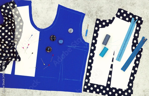 Fototapeta The process of sewing and modeling a dress from blue fabric in the form of a panorama. Pattern of clothes, fabric and accessories on the table.