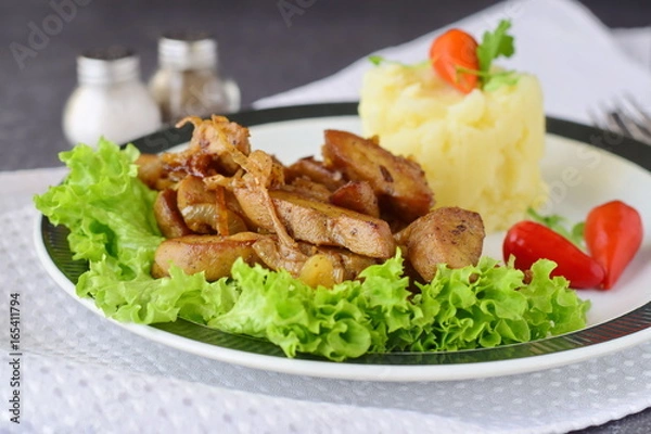 Fototapeta Fried bull testicles with cream and herbs served with mashed potato on a white plate on an abstract background. Healthy food concept