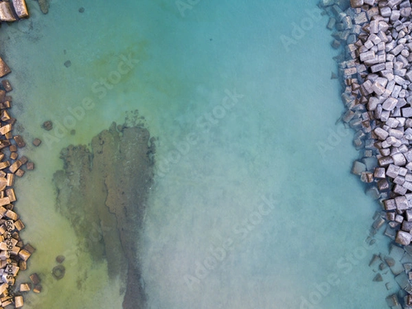 Fototapeta Vista aerea di scogli sul mare. Panoramica del fondo marino visto dall’alto, acqua trasparente