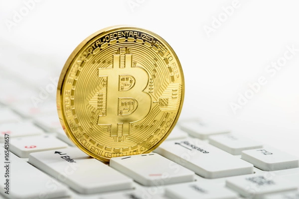 Fototapeta Golden Bitcoin on white keyboard