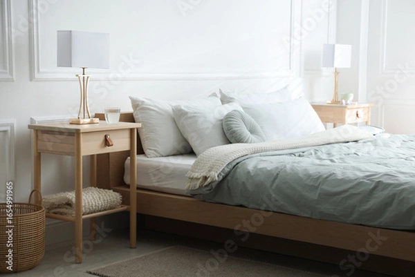 Fototapeta Bedside tables with lamps near bed indoors