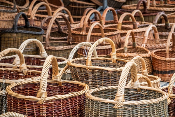 Fototapeta Colorful woven baskets displayed at a market, showcasing various sizes and styles in a lively atmosphere during a sunny afternoon
