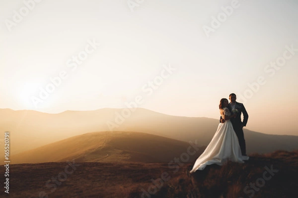 Fototapeta Beautiful gorgeous bride posing to groom and having fun, luxury ceremony at mountains with amazing view, space for text, wedding couple