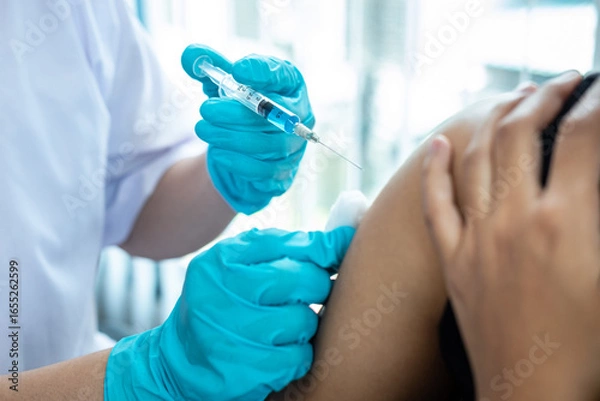 Fototapeta Doctor making a vaccination into patient with needle getting immune vaccine at arm for flu shot, coronavirus protective of epidemic