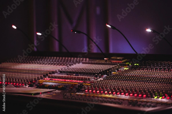 Fototapeta Professional Audio Mixing Console with Illuminated Controls and Equipment
