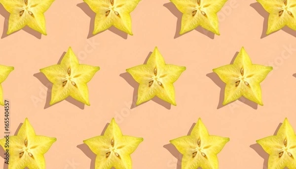 Obraz Vibrant star fruit slices arranged in a repeating pattern on a peachy pastel background