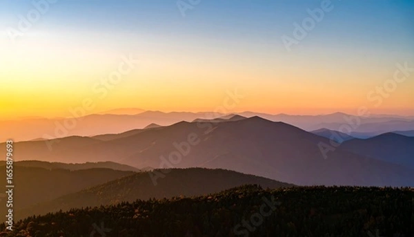 Fototapeta A vast panorama of mountain ranges bathed in the warm hues of a serene sunrise.