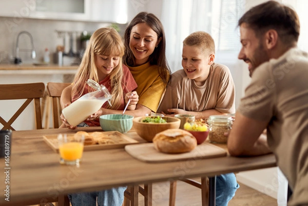 Fototapeta Happy family enjoying while having breakfast in dining room.	
