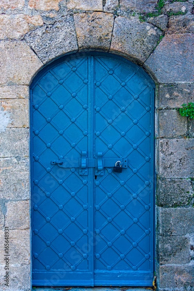 Fototapeta Blue arch ancient iron castle door with stone lintel