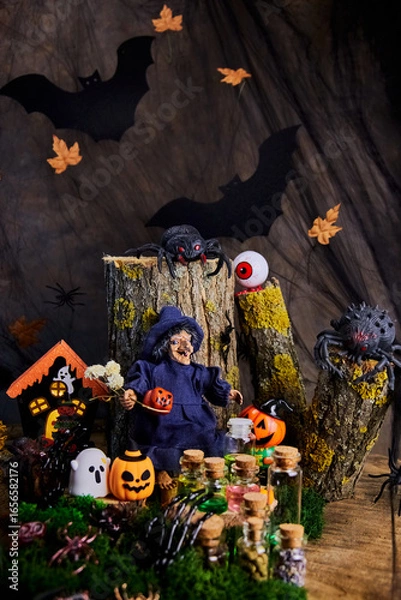 Fototapeta halloween, forest, clearing, witch sits on stump in his cozy shelter with spiders, ghost, eye, pumpkins and conjures over jars of potions on the eve of All Saints Day, selective focus