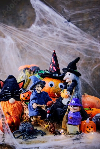 Fototapeta fun pumpkin party in a witch's cobweb forest with spiders, a gnome in a black cat costume and a bat, vertical, reative focus
