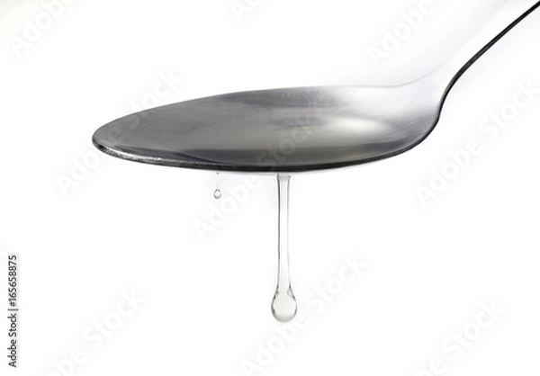 Obraz Close up syrup dripping from the spoon on white back ground