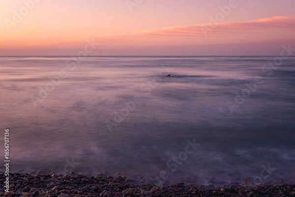 Fototapeta Solitude at Sunrise: Tranquil Beach with Smooth Water Effect