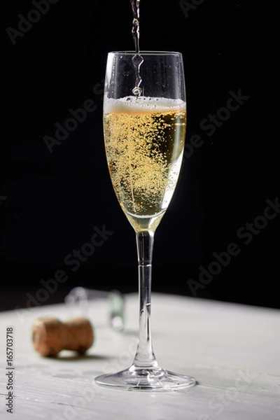 Obraz A glass of champagne on a black background