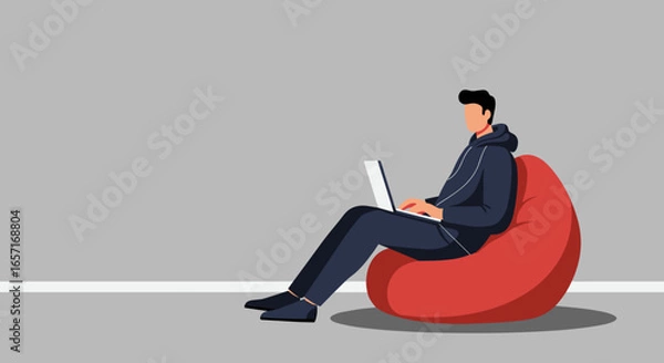 Fototapeta A young man comfortably uses his laptop on a red bean bag chair, embodying relaxed remote work or digital learning. Ideal for lifestyle, business, or technology themes.