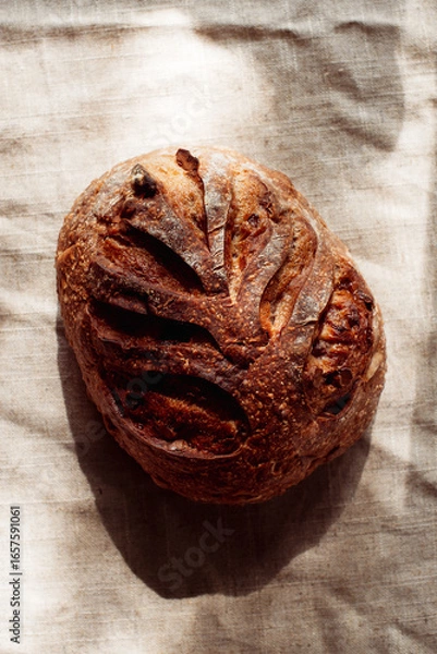 Fototapeta cranberry walnut sourdough bread on natural linen texture background.
