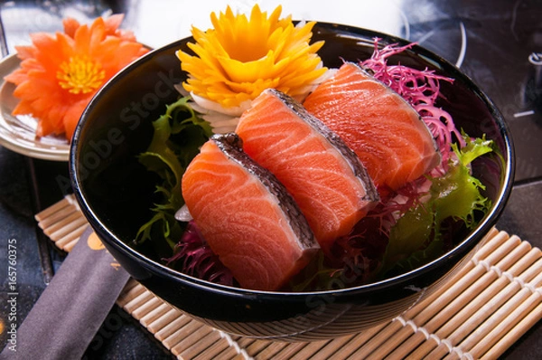 Obraz salmon sashimi on black dish on table background