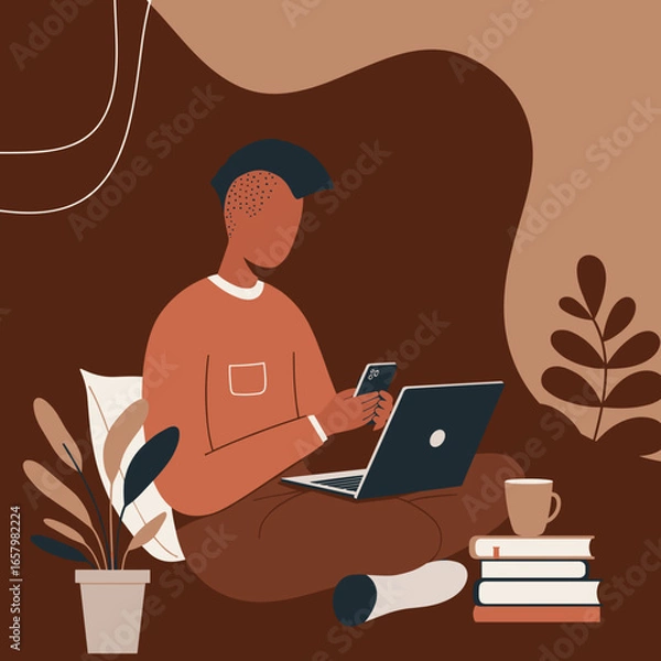 Fototapeta A young person comfortably works or studies from home, cross-legged with a laptop and smartphone. Represents remote work, online learning, and modern digital lifestyle.