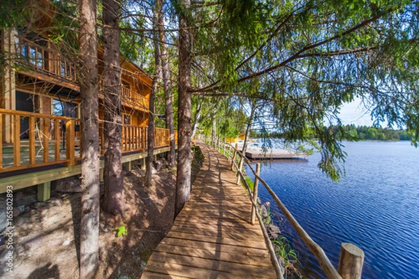 Fototapeta Wooden paths near the lake in the spring forest of Karelia