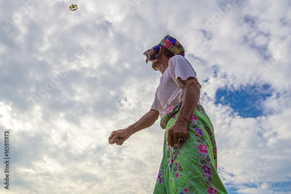 Obraz Unidentified man is playing the traditional moon kite or locally known as "Wau Bulan" in Kelantan, Malaysia.