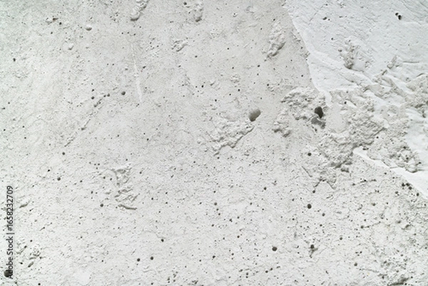 Fototapeta Closeup of rough textured white concrete surface ideal for construction, background, or design projects. Suitable for textures and backgrounds.