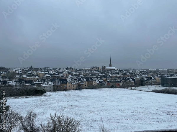 Fototapeta Flat plot ready for construction, covered in snow, with an aerial view of a residential neighborhood in Luxembourg in winter.