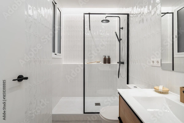 Fototapeta Modern bathroom with a glass shower, white tiles, and wooden accents. Minimalist design featuring a sink and decorative items on the counter.