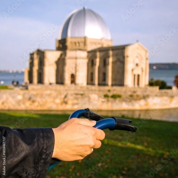 Obraz Hands holding bike handlebars in front of a church