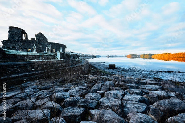 Obraz Graveyard and abbey at Donegal Town in Ireland during sunrise covered with frost and ice in the winter with ocean and sky in the background