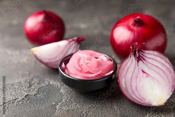 Fototapeta Pickled onions in a glass jar on the table. pickled red onion. Vegetarian spicy dish. Delicious homemade marinated pickled purple onions . Space for text. Copy space.