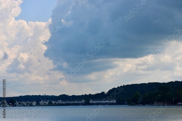 Obraz Vast Lake Under a Bright Sky With Scattered Fluffy Clouds Reflecting on Serene Water in a Peaceful Natural Setting During Daytime