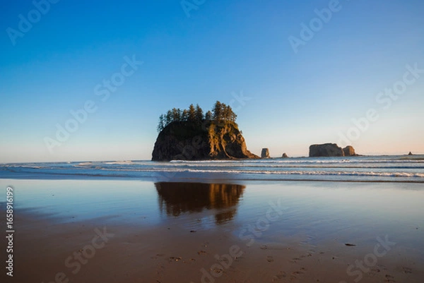 Fototapeta Scenic view of Second Beach at sunset in Olympic National Park, Washington State. Dramatic sea stacks, golden sky, and peaceful waves along the rugged Pacific Northwest coast.
