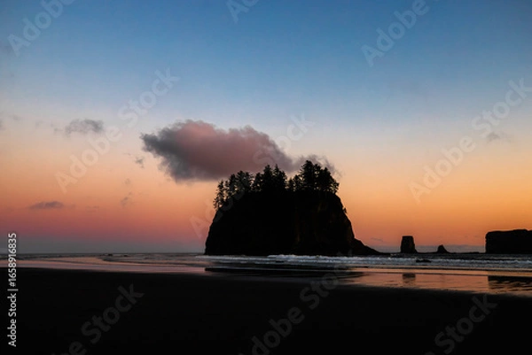 Fototapeta Sunset at Second Beach, Olympic National Park, Washington. Silhouettes of sea stacks and gentle ocean waves under a glowing sky.