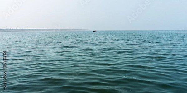 Fototapeta Serene Ocean View With Calm Waves and Distant Boat Under Clear Sky